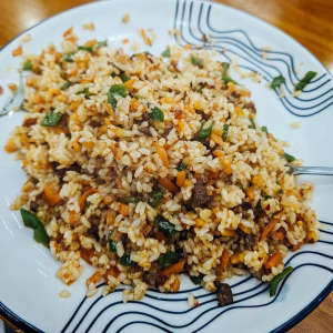 Smoky wok-fried rice with tender beef strips, carrots, green peppers, and aromatic seasoning.